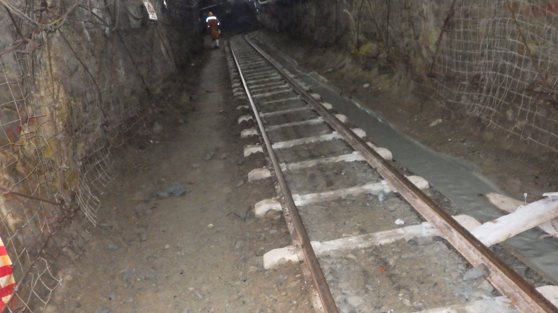 Cross Cut Management: Concrete side drain. Newly cast concrete side drain carrying water away from the cleared track bed of an active rail haulage.