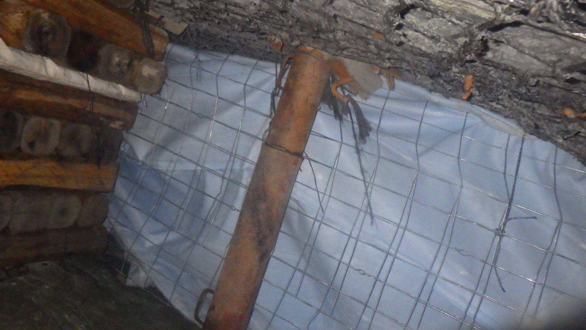 Backfill Contracting: Mesh and prop preparation. Wire mesh and white backfill fabric beside a steel support prop and timber pack, showing construction before backfill placement.